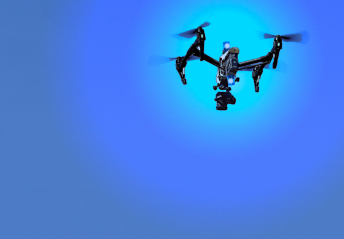 A multicopter on a blue background with lights attached to it